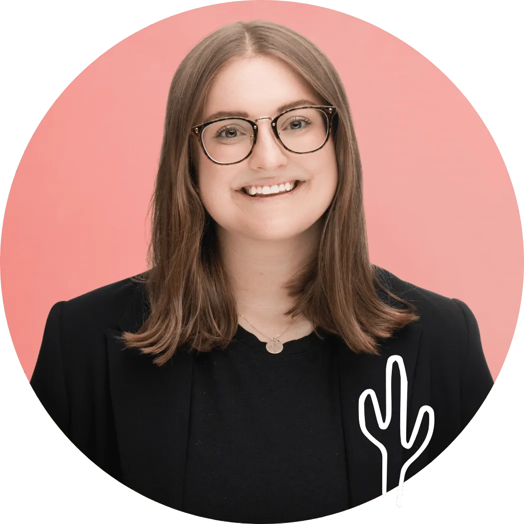 Amelia Riehl smiling in glasses against a pink background