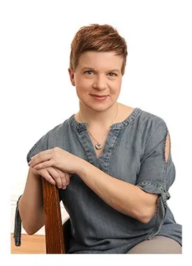 Sarah Pinsent sitting on a chair in a grey shirt