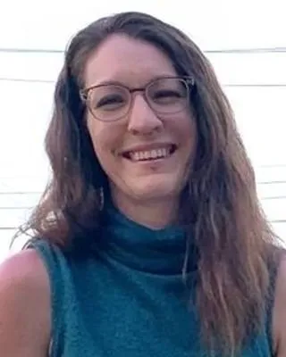 Stacie Johnson smiling outdoors in a teal top